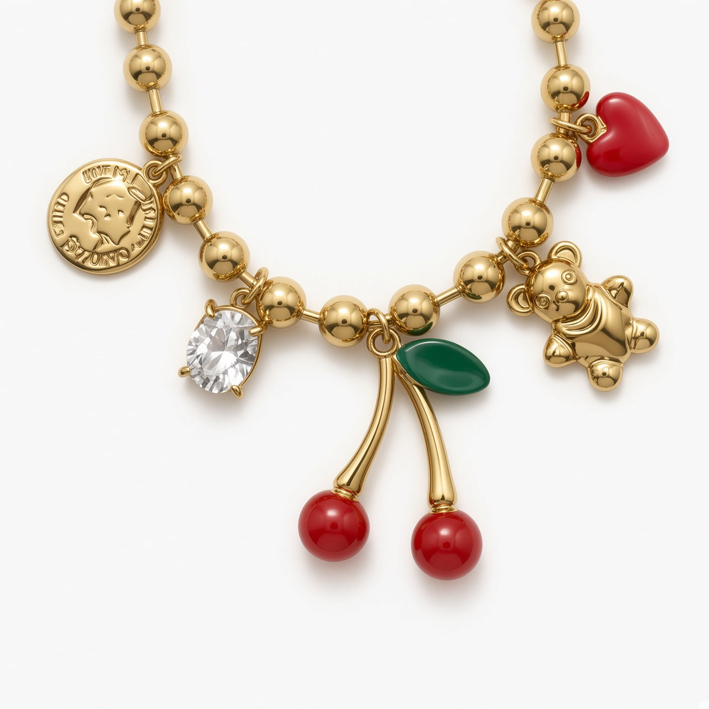 Zoom sur le bracelet cerises rouge et doré avec charms