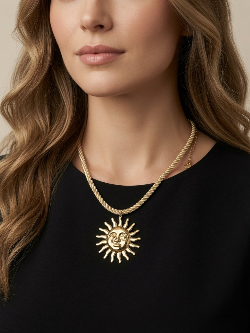 Collier Riviera à cordon beige avec grand pendentif soleil doré en acier inoxydable, porté